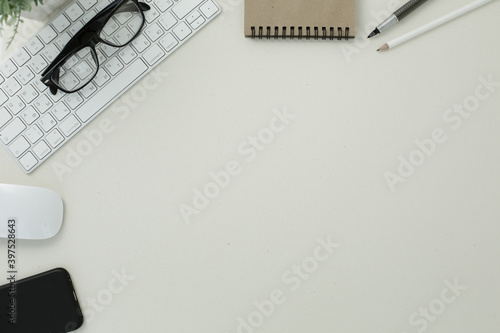 Keyboard mouse glasses pen pencil notepad phone on white background