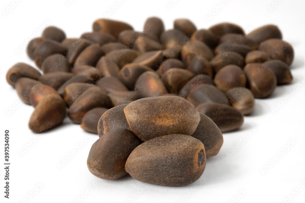 Five pine nuts and a bunch of nuts on a white background. Five pine nuts and a bunch of nuts on a white background.