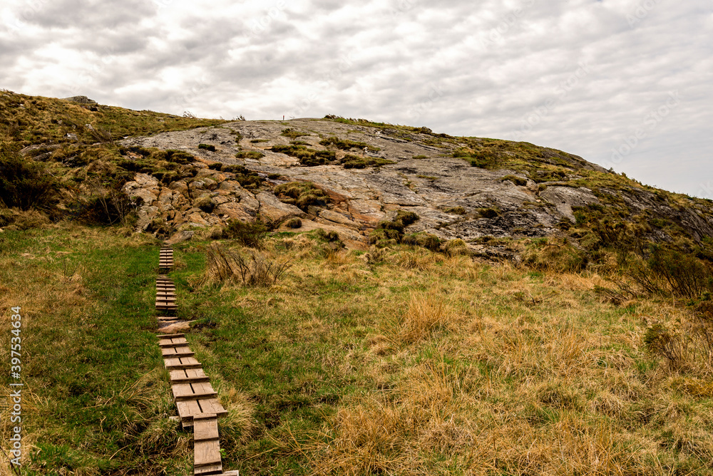 Wooden boardwalk steps on a hiking track leading to top of Mastravarden hill on Mosteroy island, Rennesoy kommune, Stavanger, Norway, May 2018
