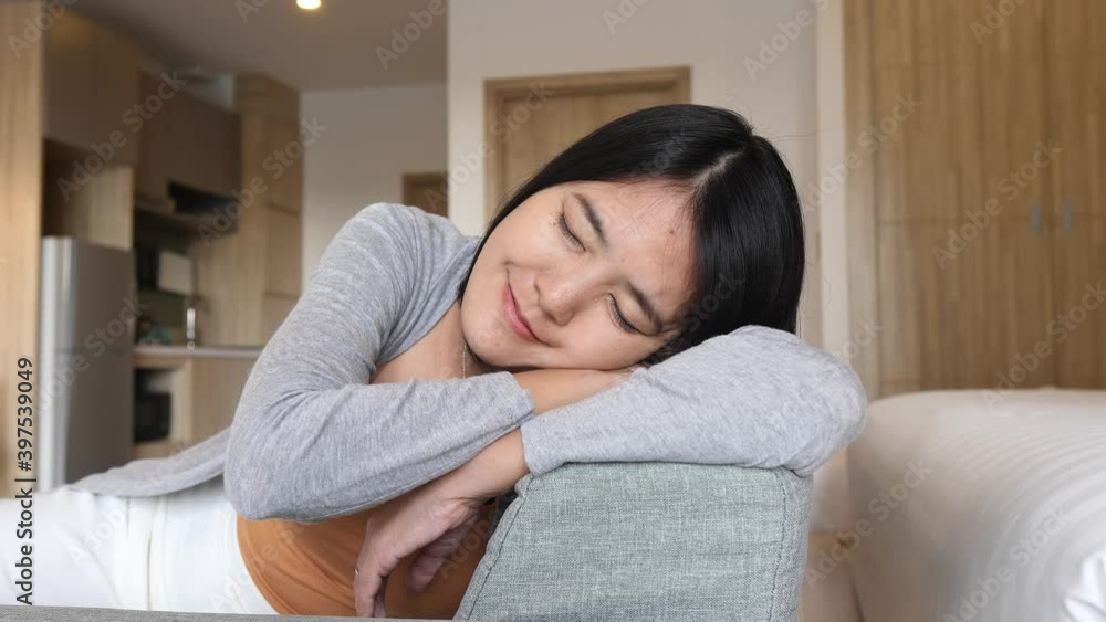 Happy asian woman napping while sitting on couch in living room ,Comfortable sofa enjoying,Relaxing time Happy asian woman napping while sitting on couch in living room ,Comfortable sofa enjoying,Relaxing time