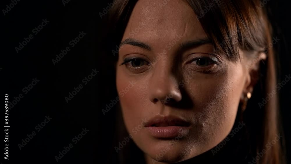 Portrait of a close-up face of a young beautiful brunette woman, with natural beauty. Located in the Studio on a black background. Portrait of a close-up face of a young beautiful brunette woman, with natural beauty. Located in the Studio on a black background.