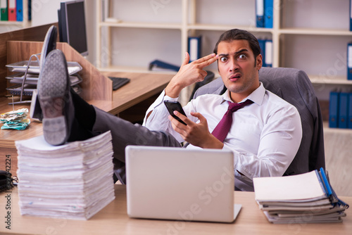 Young male employee extremely tired with excessive work