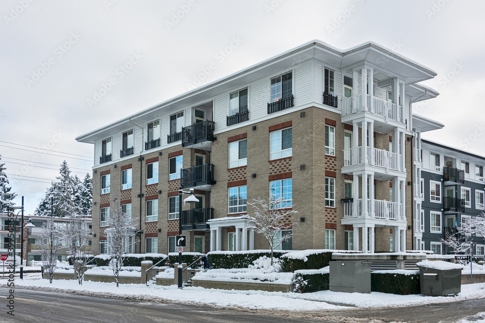 Residential low-rise building on winter day with white sky background
