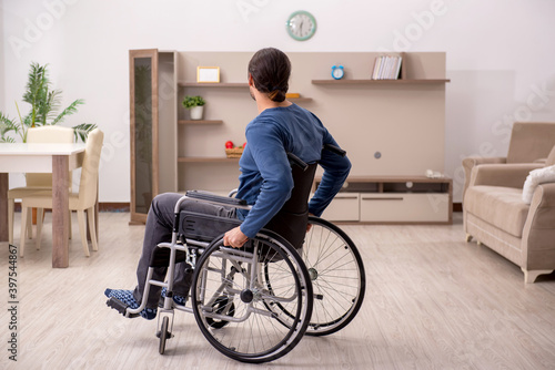 Young man in wheel-chair suffering at home