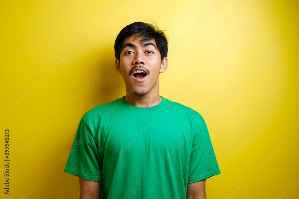 Shocked face of Asian man in green t-shirt Shocked face of Asian man in green t-shirt