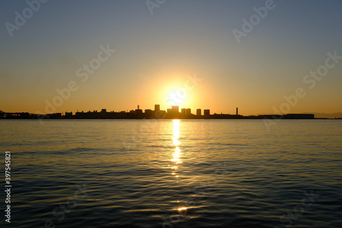 神戸ハーバーランドからの夜明け。太陽の光が波に反射して輝く © 宮岸孝守