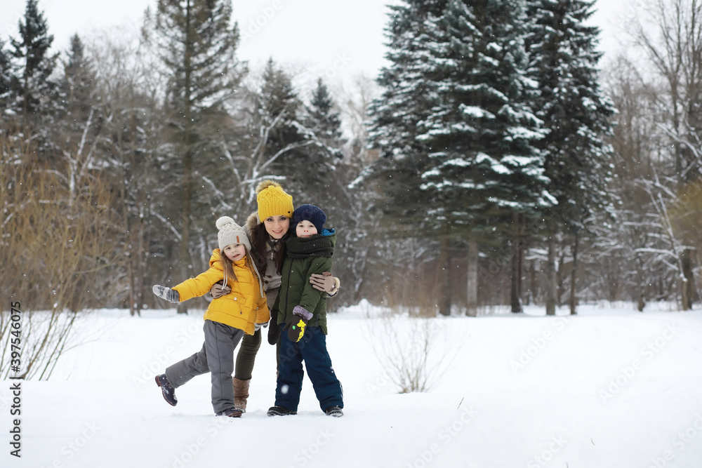 Happy family playing and laughing in winter outdoors in the snow. City park winter day.