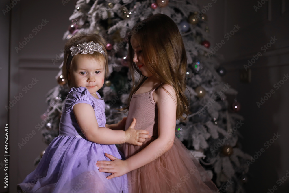 Child in smart clothes in front of the Christmas tree. Waiting for the new year.