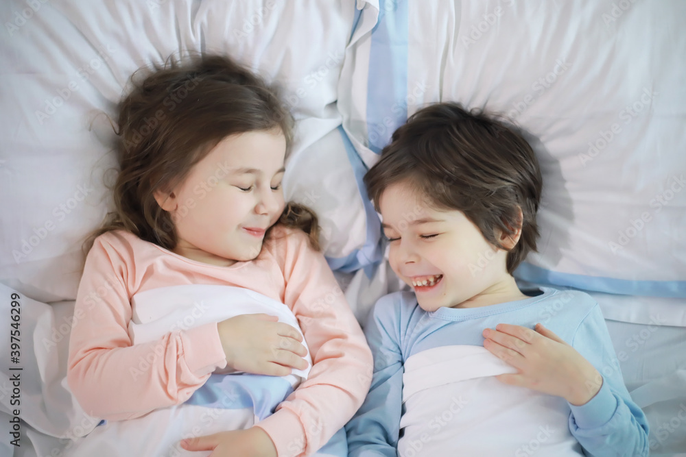 A family with children having fun on the bed under the covers during the Christmas holidays. A family with children having fun on the bed under the covers during the Christmas holidays.