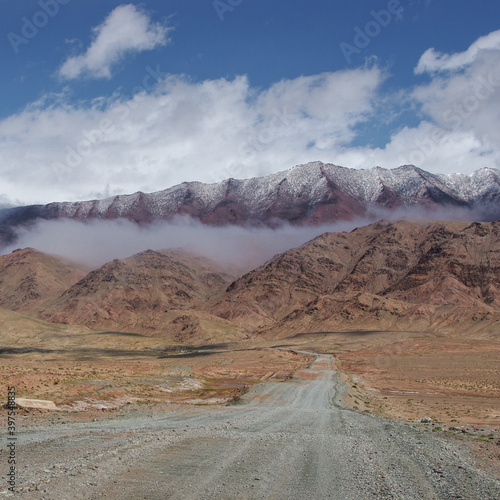 Colorful view of high-altitude Pamir Highway dirt road leading to border between Tajikistan and Kyrgyzstan at Kyzyl Art pass in the Trans-Alai mountain range, Murghab district, Gorno-Badakshan