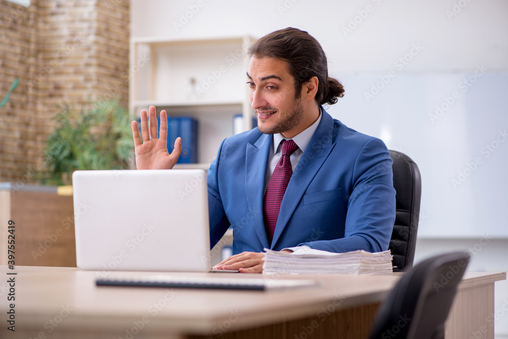 Young male employee sitting in the office in front of whiteboard Young male employee sitting in the office in front of whiteboard