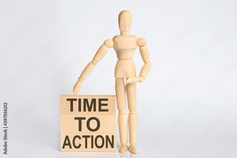 Wooden man shows with a hand text TIME TO ACTION concept on wooden block Wooden man shows with a hand text TIME TO ACTION concept on wooden block