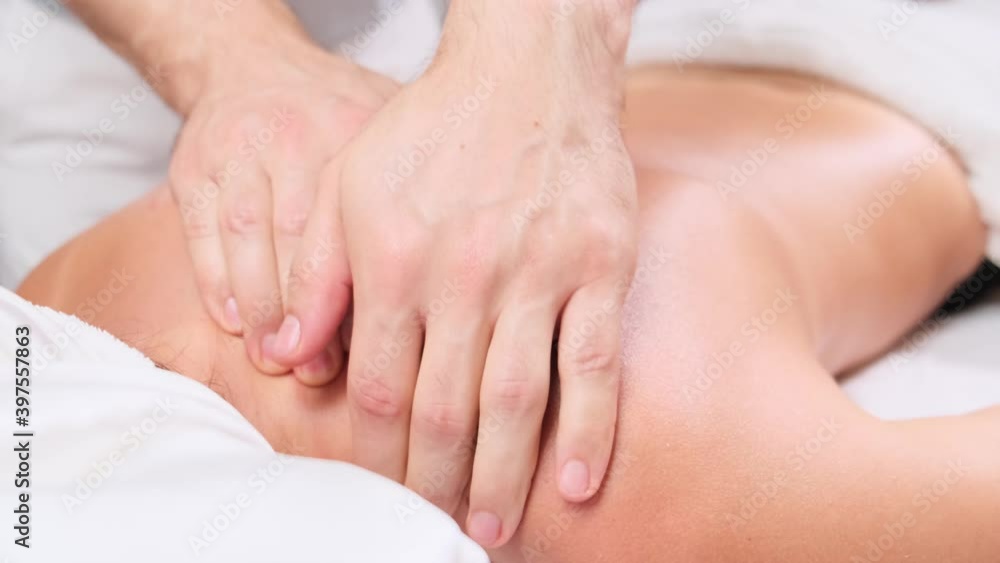 Man therapist doing massage to female patient lying on couch in spa cabinet. Female client getting back massage rejuvenating procedure in beauty clinic. massage of shoulders and neck. Man therapist doing massage to female patient lying on couch in spa cabinet. Female client getting back massage rejuvenating procedure in beauty clinic. massage of shoulders and neck.