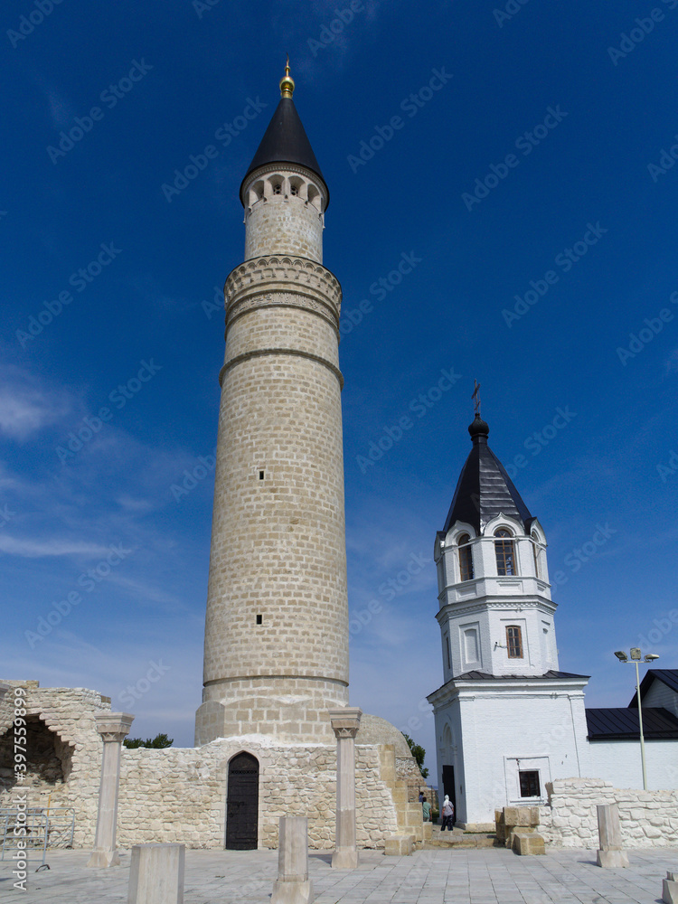 A fusion of two cultures: an Orthodox bell tower and an Islamic minaret in the ancient capital of the Golden Horde. Bolgar, Republic of Tatarstan, Russia