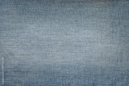 Denim texture. Light denim background with darkened corners and light center. Focusing in the center of the frame.