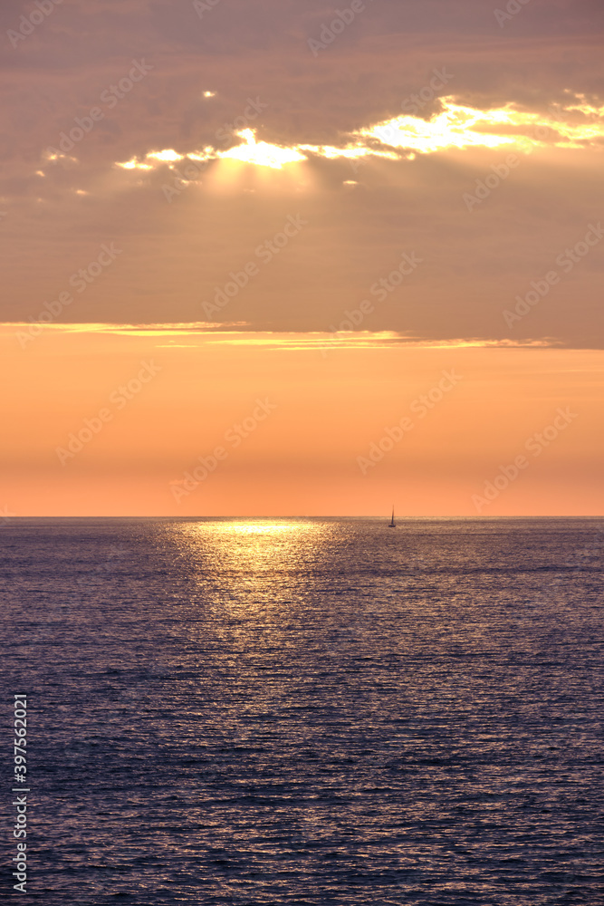 rayos de luz del sol sobre el mar con barco en el horizonte