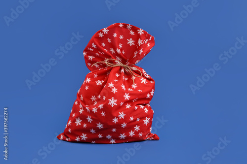 Santa Claus bag on color background