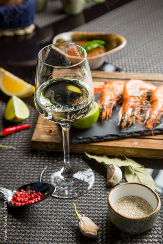 glass of white table wine with a variety of snacks. Dry white wine in the glass.