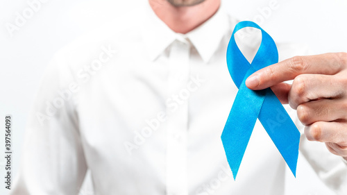 Prostate care. Awareness prostate of men health in November. Hipster men in bright shirt with blue ribbon in hands on white background. World cancer day and world diabetes day concept.