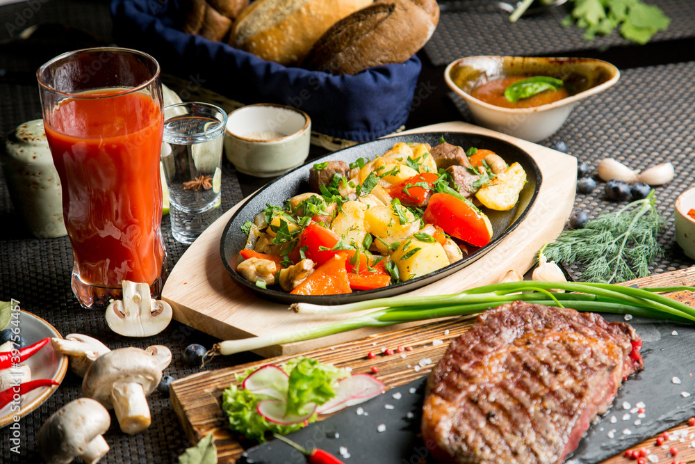 Tasty roast of vegetables and meat with tomato juice. Tomato juice in a glass. Tasty roast of vegetables and meat with tomato juice. Tomato juice in a glass.