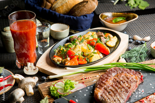 Tasty roast of vegetables and meat with tomato juice. Tomato juice in a glass.