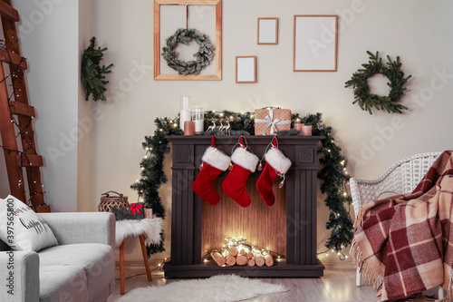 Decorated fireplace in interior of room on Christmas eve Fototapeta