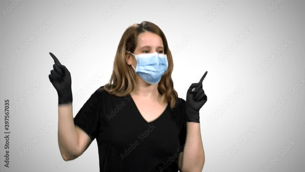 Woman with surgical mask and gloves dancing and celebrating, extremely happy, over white background. Woman with surgical mask and gloves dancing and celebrating, extremely happy, over white background.