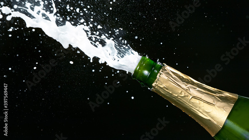 Champagne explosion with flying cork closure, opening champagne bottle closeup, celebration theme.