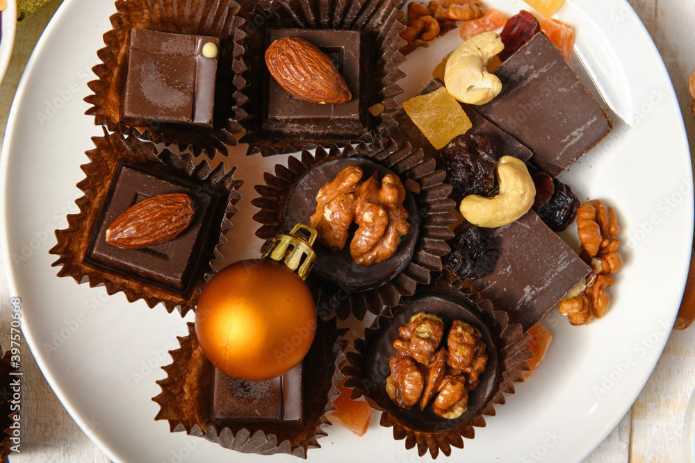 sweet food background for christmas or holiday decoration - chocolate candies, tangerines, nuts and dried fruits on white wood sweet food background for christmas or holiday decoration - chocolate candies, tangerines, nuts and dried fruits on white wood