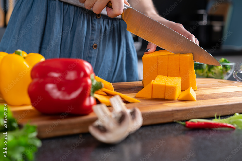Preparing for home party. Woman dice pumpkin on cutting board. Preparing for home party. Woman dice pumpkin on cutting board.