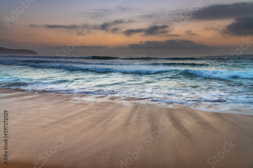 Beautiful sunrise with high cloud and headland at the seaside