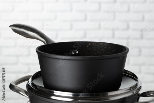 Set of cookware on table against white brick wall