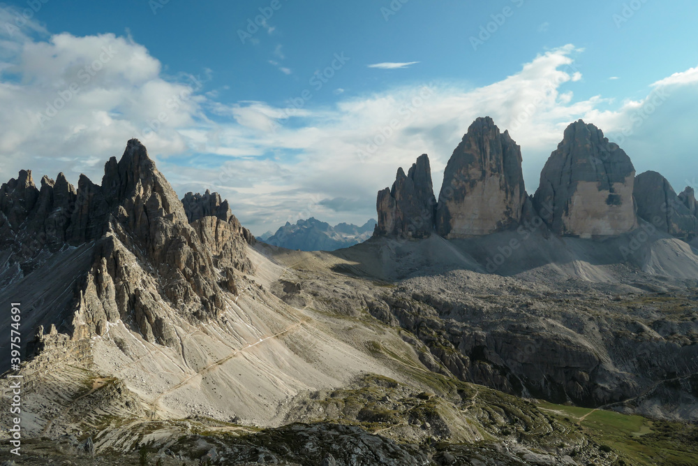 A panoramic capture of the famous Tre Cime di Lavaredo (Drei Zinnen) and surrounding mountains in Italian Dolomites. The mountains are surrounded by thick clouds. A lot of landslides. Serenity