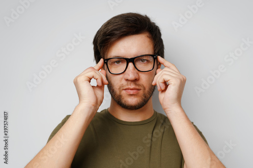 Portrait of a serious pensive young man against grey background