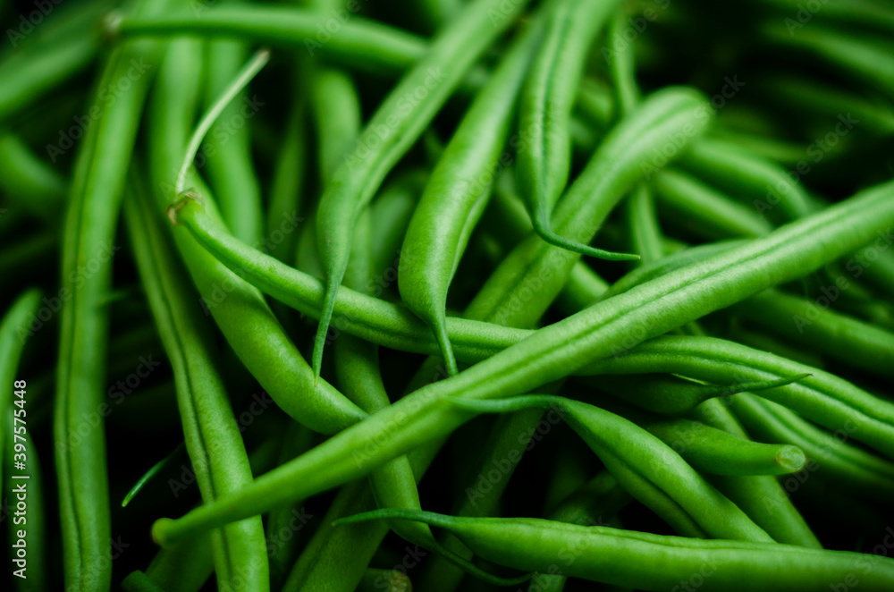 Close up green beans on a black background with soft light Close up green beans on a black background with soft light