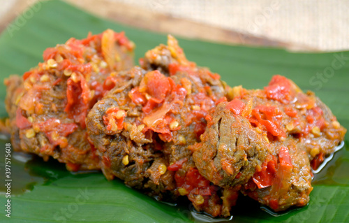 Dendeng Balado or Dendeng Batokok, and is a speciality from Padang, West Sumatra, Indonesia. Made from beef which is thinly cut then dried and fried before adding chillies and other ingredients photo