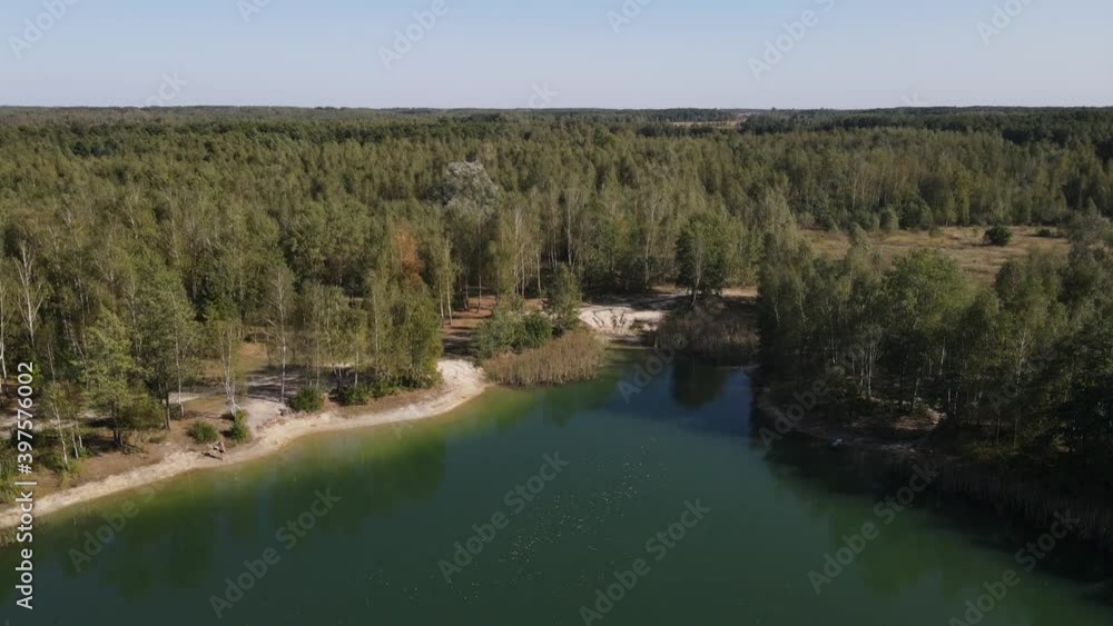 There is a sandy shore around the river. Trees grow densely nearby. View frome the drone. There is a sandy shore around the river. Trees grow densely nearby. View frome the drone.