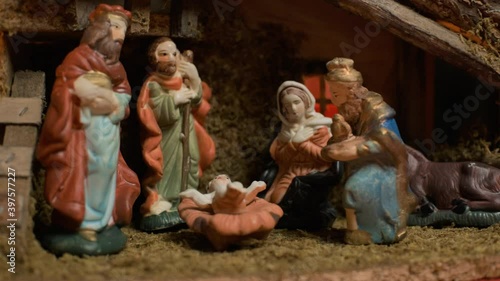 Woman puts miniature figurines. Beautiful nativity scene and christmas decorations - close view photo
