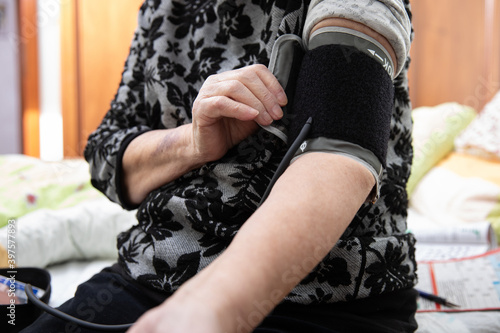 Senior woman measuring her blood pressure at home