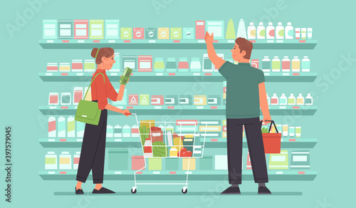 Happy woman and man, shoppers in a grocery market are choosing food on the shelves. Supermarket customers
