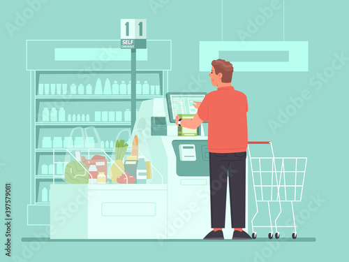 Self-service cashier in the supermarket. A man customer rings up groceries at a self-checkout terminals at a grocery store