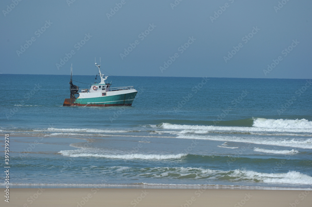Naklejka premium Fisherman on his boat on the coast