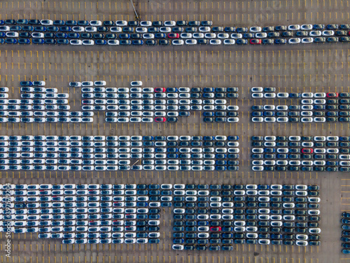 Top view of many parked cars waiting for shipping aerial drone view lined up structured