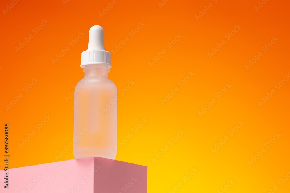 Beauty oil bottle with pipette against orange background Beauty oil bottle with pipette against orange background