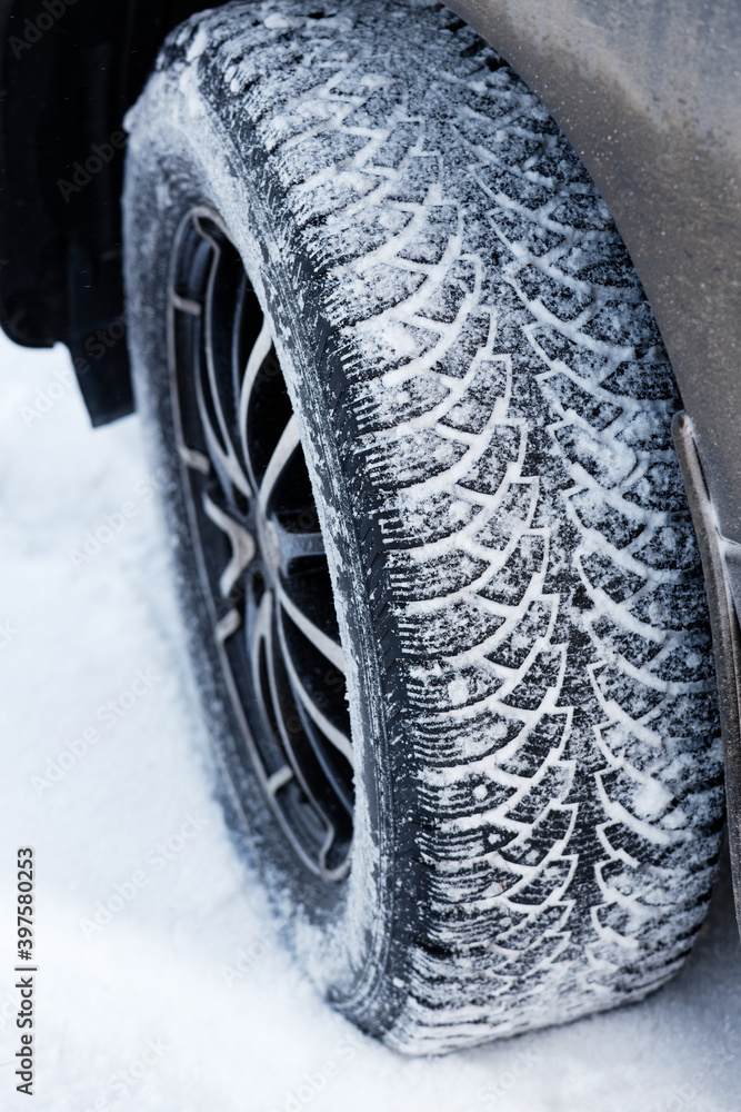 Closeup winter wheel with iron spikes for mud and snow terrain. Shallow focus.