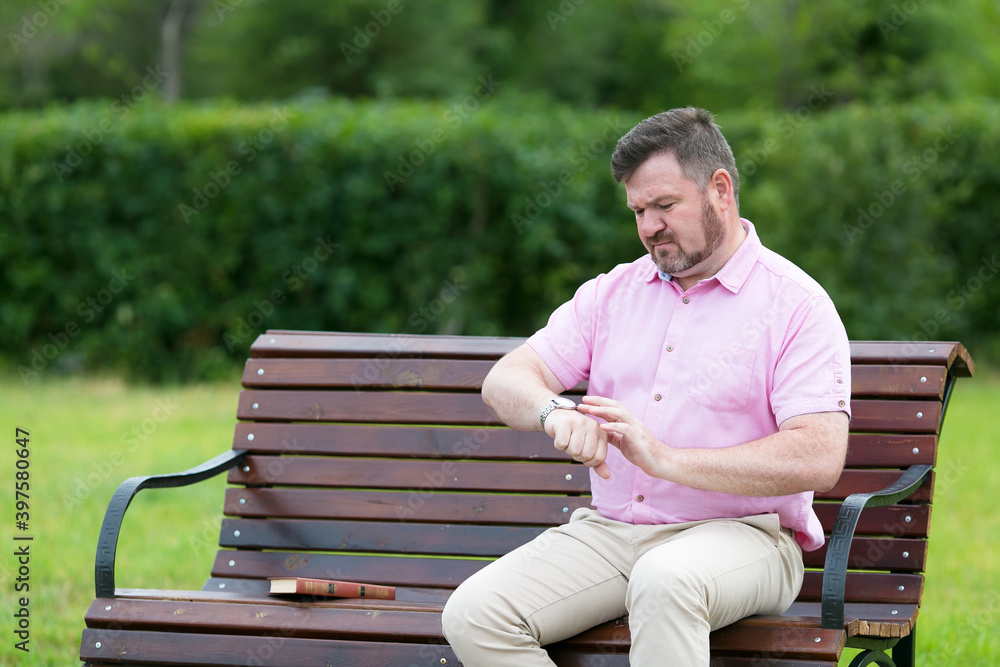 Man waiting for a late woman on a date in the park. Man waiting for a late woman on a date in the park.