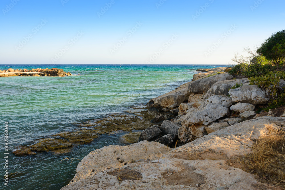 Rocky shore of the azure sea on a summer evening