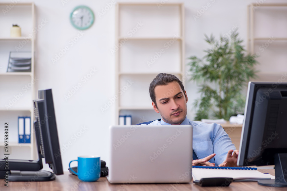 Young male employee working in the office Young male employee working in the office