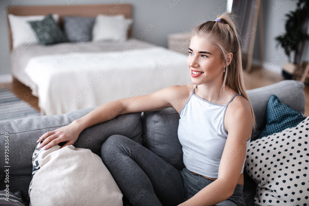 Beautiful smiling fitness woman relax on the couch at home Beautiful smiling fitness woman relax on the couch at home