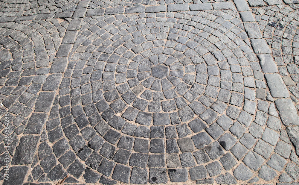 Stones laid close to each other (paving stones) as road surface in summer Stones laid close to each other (paving stones) as road surface in summer